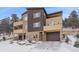 Contemporary home exterior with stone accents, balconies, and garage, surrounded by a snowy landscape at 726 Dreamcatcher Ln, Evergreen, CO 80439