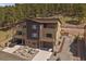 Modern three-story townhouse with attached garages, balconies, and native landscaping in a wooded neighborhood at 726 Dreamcatcher Ln, Evergreen, CO 80439