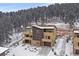 Modern townhouse featuring multi-tone exteriors, private balconies, and attached garages nestled against a snowy wooded backdrop at 726 Dreamcatcher Ln, Evergreen, CO 80439