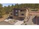 Three-story townhouse showing an attached garage, multiple balconies, with natural boulders and native plants in the yard at 726 Dreamcatcher Ln, Evergreen, CO 80439