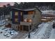 Modern townhouse featuring multi-tone exteriors, private balconies, and attached garages nestled against a snowy wooded backdrop at 726 Dreamcatcher Ln, Evergreen, CO 80439