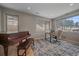 Bright home office with desk, chair, and a piano with a view of snow-covered trees at 726 Dreamcatcher Ln, Evergreen, CO 80439