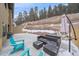 An elegant outdoor patio with a conversation set and umbrella surrounded by the natural beauty of the hillside at 726 Dreamcatcher Ln, Evergreen, CO 80439