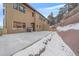 Back of house showing patio area with barbecue and snowy yard at 726 Dreamcatcher Ln, Evergreen, CO 80439