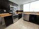 Modern kitchen features stainless steel appliances, sleek black backsplash, and butcher block countertops at 1155 Ash St # 202, Denver, CO 80220