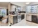 Modern kitchen features dark cabinetry, stainless steel appliances, and a seamless connection to the living room at 1155 Ash St # 202, Denver, CO 80220