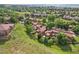 Aerial view of a residential community with tree-lined streets, lush greenery, and mountain views in the distance at 108 Ward Ct, Lakewood, CO 80228
