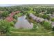 Aerial view of houses surrounding a pond with lush trees and green space, showing community and nature at 108 Ward Ct, Lakewood, CO 80228