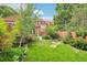 Well-maintained backyard with lush grass, stone pathway, and varied plants around the edge of the property at 108 Ward Ct, Lakewood, CO 80228
