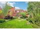 Residential backyard with green lawn, mature trees, and plants providing a private outdoor space at 108 Ward Ct, Lakewood, CO 80228