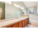 Well-lit bathroom with a double vanity, framed mirrors, and a bathtub, designed for comfort and functionality at 108 Ward Ct, Lakewood, CO 80228