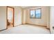 Bright bedroom with neutral carpeting, a window, and adjacent bathroom access, offers space and convenience at 108 Ward Ct, Lakewood, CO 80228