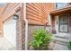 Home front entrance featuring mature landscaping, a brick trim, and a black wrought iron security door at 108 Ward Ct, Lakewood, CO 80228