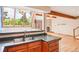 Kitchen bar counter with hardwood floors, wood cabinets, stainless steel sink, and backyard views at 108 Ward Ct, Lakewood, CO 80228