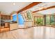 Open-concept living space featuring hardwood floors, vaulted ceilings with wood beams, and backyard views at 108 Ward Ct, Lakewood, CO 80228