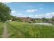 Scenic view of a pond surrounded by green grass and trees near residential houses, showcasing community beauty at 108 Ward Ct, Lakewood, CO 80228
