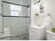 Bathroom with white subway tile, glass enclosed shower, pebble tile floor, and modern fixtures at 1805 W 51St Ave, Denver, CO 80221