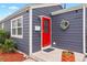 Charming home featuring a striking red front door, stylish wreath, and newly painted gray siding at 1805 W 51St Ave, Denver, CO 80221