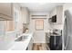 Well-lit kitchen featuring subway tile backsplash, stainless steel appliances, and modern grey cabinetry at 1805 W 51St Ave, Denver, CO 80221