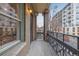 Balcony with brick columns and wrought iron railing, overlooking the cityscape and offering outdoor relaxation space at 1210 E Colfax Ave # 301, Denver, CO 80218