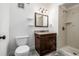 Traditional bathroom featuring a vanity with granite countertop, toilet, and a tiled shower, providing essential amenities at 1210 E Colfax Ave # 301, Denver, CO 80218