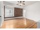 Spacious bedroom with hardwood floors, exposed brick wall, large window, and ceiling fan at 1210 E Colfax Ave # 301, Denver, CO 80218