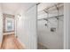 Hallway with closet featuring wood floors and an exposed brick accent wall with natural light from the window at 1210 E Colfax Ave # 301, Denver, CO 80218