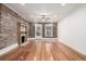 Cozy living room featuring exposed brick, fireplace, a ceiling fan and ample natural light at 1210 E Colfax Ave # 301, Denver, CO 80218