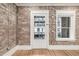 Living room with exposed brick wall, adjacent to a window and an entryway door at 1210 E Colfax Ave # 301, Denver, CO 80218