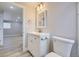 Clean basement bathroom with white vanity, toilet and a large mirror at 3227 N Steele St, Denver, CO 80205