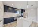 Modern kitchen with white island and dark blue cabinets at 3227 N Steele St, Denver, CO 80205