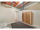 Unfinished basement with exposed ceiling, wine rack, and open door to additional room at 5284 Taft Ct, Arvada, CO 80002
