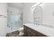 Modern bathroom with a glass-enclosed shower, dark vanity with marble countertop and sleek fixtures at 5284 Taft Ct, Arvada, CO 80002