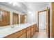 Bathroom featuring double sinks, spacious countertop, and classic wood cabinetry at 5284 Taft Ct, Arvada, CO 80002
