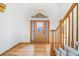 Bright foyer features hardwood floors, a decorative front door, and a staircase with wood railings at 5284 Taft Ct, Arvada, CO 80002