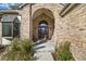 Inviting front entryway featuring a brick archway, decorative glass door, and manicured front garden at 5284 Taft Ct, Arvada, CO 80002