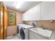 Well-equipped laundry room with modern washer and dryer, sink, and ample cabinet space at 5284 Taft Ct, Arvada, CO 80002