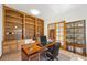 Well-lit home office with built-in bookshelves, desk, and glass-paneled door offers a professional workspace at 5284 Taft Ct, Arvada, CO 80002