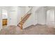 View of carpeted stairs with wood banister and white trim, with doors on both sides in an entry area at 5284 Taft Ct, Arvada, CO 80002