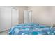 Bedroom featuring blue quilt, closet space, and view of open doorway at 11250 Florence St # 5C, Commerce City, CO 80640