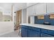 Kitchen view with blue cabinets, white countertop, mosaic backsplash, leading into the entryway and living room at 11250 Florence St # 5C, Commerce City, CO 80640