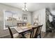 Bright dining area featuring a modern chandelier, a window with blinds, and a view of the neighborhood at 21093 E 53Rd Ave, Denver, CO 80249