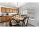 Breakfast nook with dark wooden cabinets and chairs, illuminated by a modern chandelier and natural light at 21093 E 53Rd Ave, Denver, CO 80249