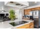 Modern kitchen island with white countertop and cooktop with stainless steel appliances at 21093 E 53Rd Ave, Denver, CO 80249