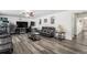 Relaxing living room featuring hardwood flooring, a dark leather sofa, and entertainment center at 21093 E 53Rd Ave, Denver, CO 80249