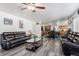 Open concept living room with gray flooring, dark couches and kitchen in the background at 21093 E 53Rd Ave, Denver, CO 80249