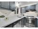 Modern galley kitchen with gray cabinets and quartz countertops at 5401 E Warren Ave # 204, Denver, CO 80222