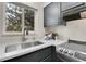 Modern kitchen sink with a stainless steel sink and gray cabinets at 5401 E Warren Ave # 204, Denver, CO 80222