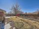 Landscaped backyard with garden and shed. Features a large tree and wood fence at 2525 Nelson St, Lakewood, CO 80215