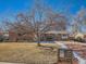 Brick ranch home with mature tree, landscaped yard, and paved driveway at 2525 Nelson St, Lakewood, CO 80215